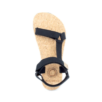 Black Mukishoes Solstice. Sandals have thicker cotton adjustable straps going over the toes and surrounding the ankle with straps connecting the toe and ankle straps. Footbed is quark and sole is a thin black rubber. Right shoe is shown here from above against a white background. #color_black