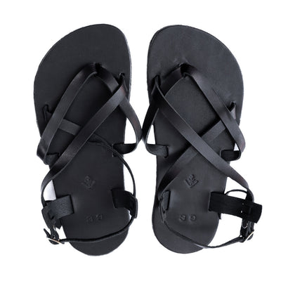 A black leather strappy sandal with a silver buckle in the back. Both sandals are shown from above against a white background. #color_black