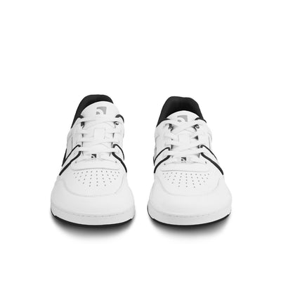 A photo Barebarics Arise chunky leather sneaker in white with black and white soles and white laces. Shoes are perforated on the sides and toe box and have green detailing on the soles, both sides of the shoe, and the lining. Both shoes are shown from the front against a white background. #color_white-black