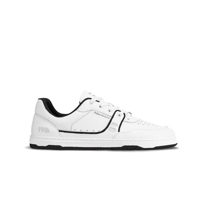 A photo Barebarics Arise chunky leather sneaker in white with black and white soles and white laces. Shoes are perforated on the sides and toe box and have green detailing on the soles, both sides of the shoe, and the lining. Right shoe is shown facing right against a white background. #color_white-black