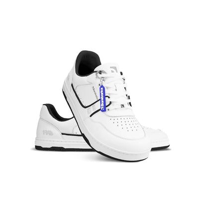 Photo 1 - A photo Barebarics Arise chunky leather sneaker in white with black and white soles and white laces. Shoes are perforated on the sides and toe box and have green detailing on the soles, both sides of the shoe, and the lining. Left shoe is shown facing right while the left shoe is propped on the right foot opening against a white background. Photo 2 - Both shoes are shown from the top down against a white background. #color_white-black