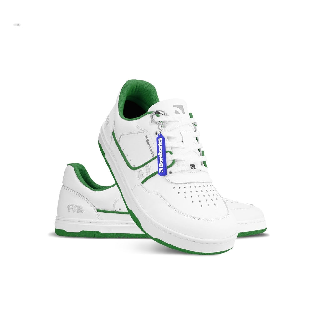 Photo 1 - A photo Barebarics Arise chunky leather sneaker in white with green and white soles and white laces. Shoes are perforated on the sides and toe box and have green detailing on the soles, both sides of the shoe, and the lining. Left shoe is shown facing right while the left shoe is propped on the foot opening against a white background. Photo 2 - Both shoes are shown from the top down against a white background. #color_white-green