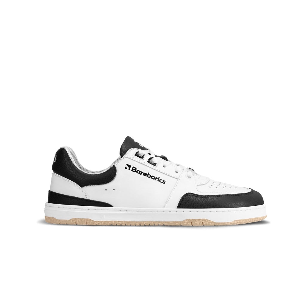 A photo of a white and black classic sneaker with a perforated toe box, the sole is white with tan tread, barebarics brand name is written on the side. The right sneaker is shown from the right side against a white background. #color_white-black