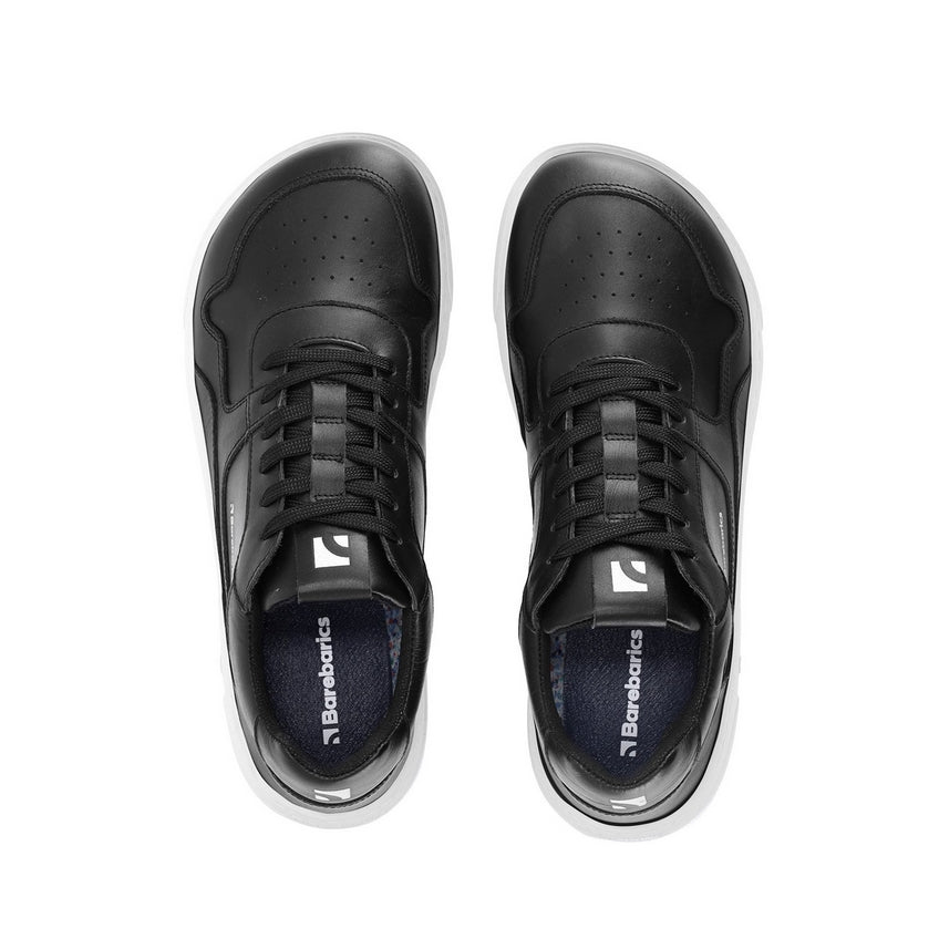 A photo of Barebarics Zing sneakers made with a leather upper and a rubber sole. The sneakers are a black color with perforated spots on the top of the toe box and barebarics branding on the tongue and side. Both sneakers are shown facing upright beside each other from the top down against a white background. #color_black-white