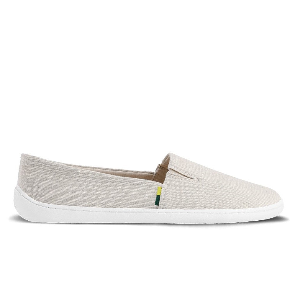 A photo of the Be Lenka Bali canvas slip on, the slip ons are a beige color with a yellow and green tag on the side. One shoe is shown from the right side against a white background. #color_beige