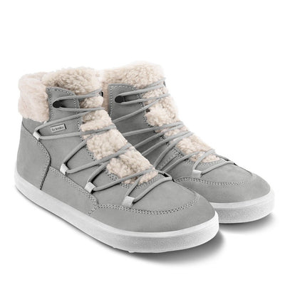 A photo of Belenka Bliss Boots made from nubuck leather and light grey rubber soles. The boots are grey and have fleece surrounding the whole tongue and around the ankle. The laces are wide across the boot top and have speed hooks at the by the top. Both boots are shown diagonally from the front right against a white background. #color_cloud-grey