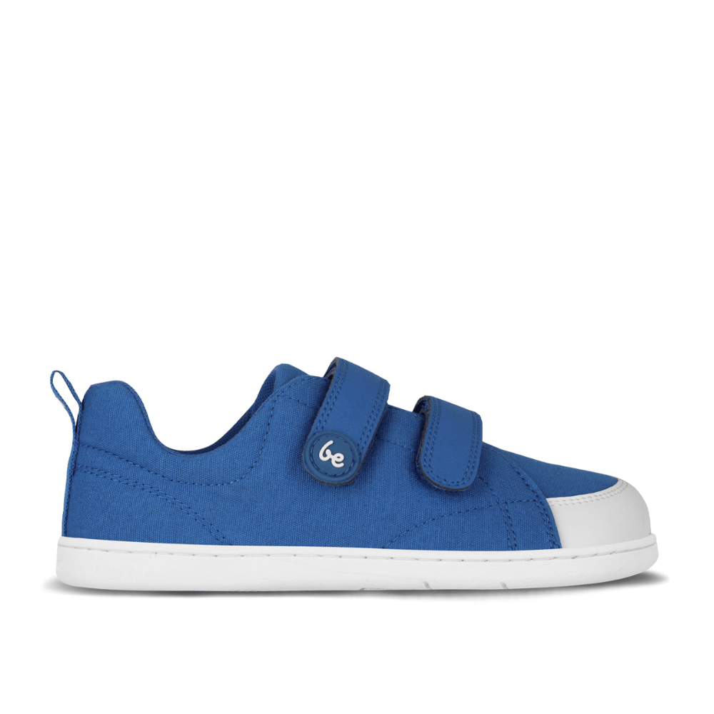 Blue canvas Be Lenka Canvi sneakers with  two velcro straps, white faux suede toe caps, white and teal rubber soles, and a pull tab at the heel. Right shoe is shown facing right against a white background. #color_blue