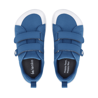 Blue canvas Be Lenka Canvi sneakers with  two velcro straps, white faux suede toe caps, white and teal rubber soles, and a pull tab at the heel. Both shoes are shown from above against a white background. #color_blue