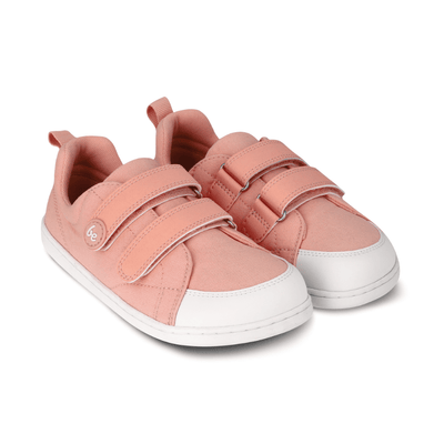 Light coral pink canvas Be Lenka Canvi sneakers with two velcro straps, white faux suede toe caps, white and coral pink rubber soles, and a pull tab at the heel. Both shoes are shown facing  diagonally right against a white background. #color_coral-pink