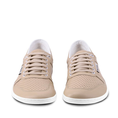 A photo of Belenka Champ sneakers made from leather and rubber soles. The sneakers are cappuccino in color with perforation on the toe box and detail stitching. Both shoes are shown beside each other from the front against a white background. #color_cappuccino