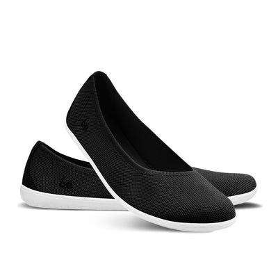 A photo of Black Be Lenka Delight knitted flats with white soles. Left shoe is shown facing right with the right shoe heel resting on the left shoe facing diagonally right against a white background. #color_black