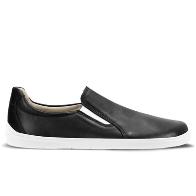 A photo of a black leather slip-on sneaker with white elastic on the sides, and a white sole. The right sneaker is shown from the right side against a white background. #color_black-white-leather