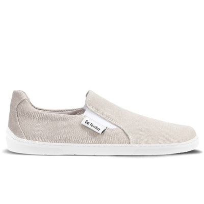 A photo of a sand canvas slip-on sneaker with white elastic on the sides, and a white sole. The right sneaker is shown from the right side against a white background. #color_sand-canvas