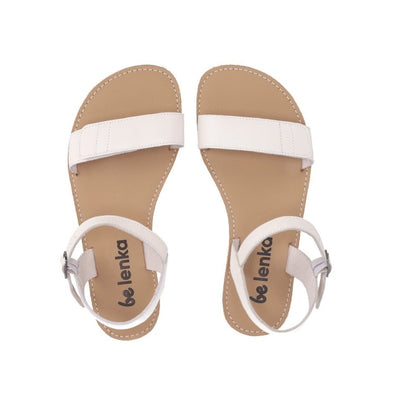 A photo of Ivory Be Lenka Grace Sandals made with leather and tan rubber soles. The sandals have shiny gold straps and a single front foot strap with straps that go around the ankle and heel and have a small buckle. Both sandals are shown diagonally from the top down against a white background in this photo. #color_ivory