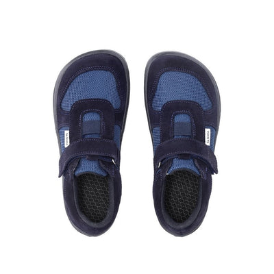 Photo 1 - A photo of Be Lenka Joy kids play shoes in dark blue and black. They are made of dark blue mesh and black suede in a classic sneaker design. A velcro strap at the top of the tongue and elastic band just below are in place of laces. Both shoes are shown diagonally from the front right against a white background. Photo 2 - Both shoes are shown from the top down against a white background. #color_dark-blue-black