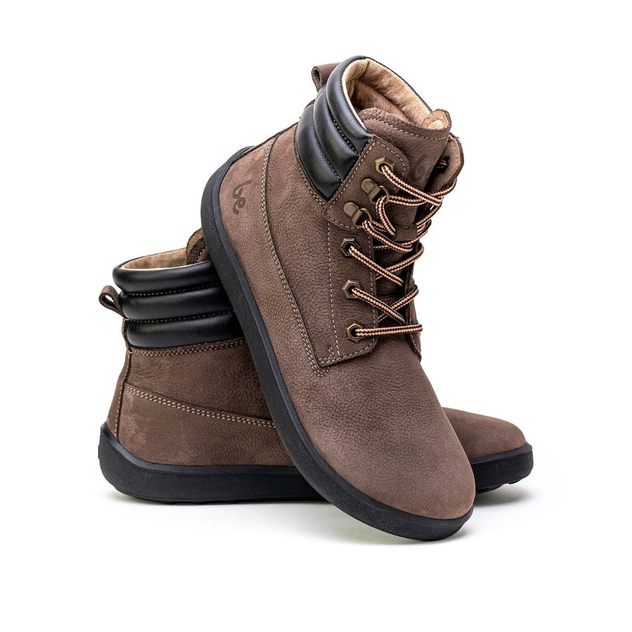 A photo of Be Lenka Nevada Boots made from nubuck leather and rubber soles. The boots are chocolate brown in color, they are combat boot style with laces, a padded collar and a chunky eyelets. Both boots are shown beside each other from the right side, the right boot’s heel is leaning on against the left boot against a white background. #color_chocolate
