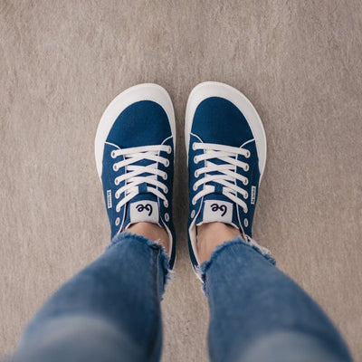 Dark Blue Be Lenka Rebound sneakers with white laces, microfiber toe guards, heel accents, and rubber soles. Both shoes are shown from above on feet standing on cement. #color_dark-blue-white