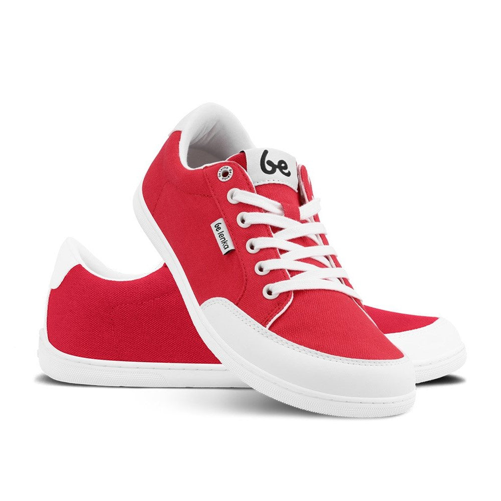 Red Be Lenka Rebound sneakers with white laces, microfiber toe guards, heel accents, and rubber soles. Left shoe is facing right with the right shoe heel resting on it facing diagonally right against a white background. #color_red-white