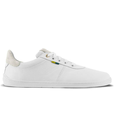 A photo of Be Lenka Royale sneakers made with a leather upper and a rubber sole. The sneakers are a white color and the area around the heel is beige, they have small yellow and blue tag on the side. The right sneaker is shown from the side against a white background. #color_white-beige