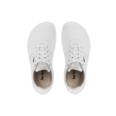 A photo of Be Lenka Royale sneakers made with a leather upper and a rubber sole. The sneakers are a white color and the area around the heel is beige, they have small yellow and blue tag on the side. Both sneakers are shown facing upright beside each other from the top down against a white background. #color_white-beige