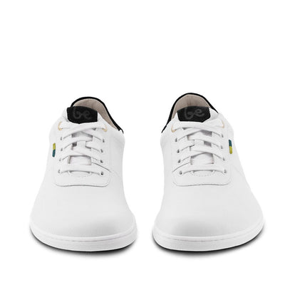 A photo of Be Lenka Royale sneakers made with a leather upper and a rubber sole. The sneakers are a white color and the area around the heel is black, they have small yellow and blue tag on the side. Both shoes are shown beside each other from the front against a white background. #color_white-black