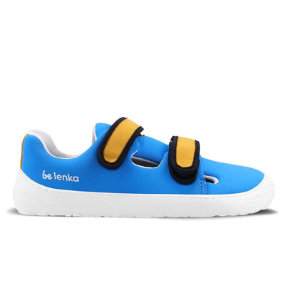 Photo 1 - A photo Be Lenka Kids Seasiders summer sandal sneakers in blue with white soles. Shoes are made of neoprene with two velcro straps. Straps are yellow with white edging, resembling a royal blue tang fish. The tongue does not quite touch the side of the shoe, leaving some breathable holes for summer time. Right shoe is shown from the right side against a white background. Photo 2 - Both shoes are shown from the top down against a white background. #color_bluelicious