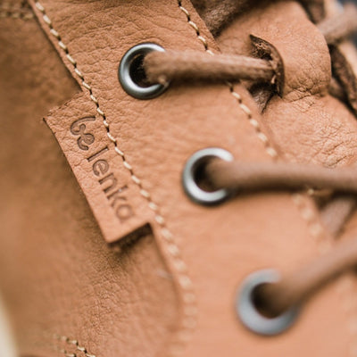 A photo of Cognac Be Lenka Synergy Leather Ankle Boots with beige rubber soles. Right boot laces are shown here in close up detail. #color_cognac-beige