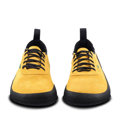 A photo of a hiking sneaker with a long heel pull on tab. Both sneakers are shown from the front. The sneakers are mustard in color with black above the sole and bump rubber thread against a white background. #color_mustard