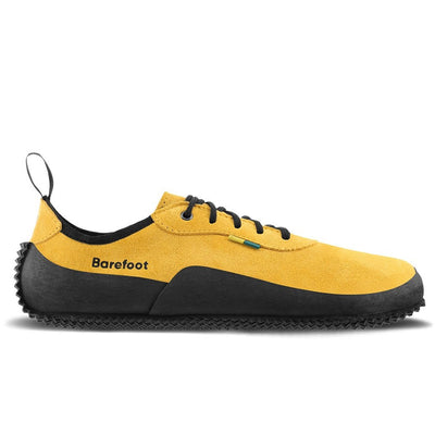 A photo of the right side of a hiking sneaker with a long heel pull on tab. The sneakers are mustard in color with black above the sole and bump rubber thread against a white background. #color_mustard