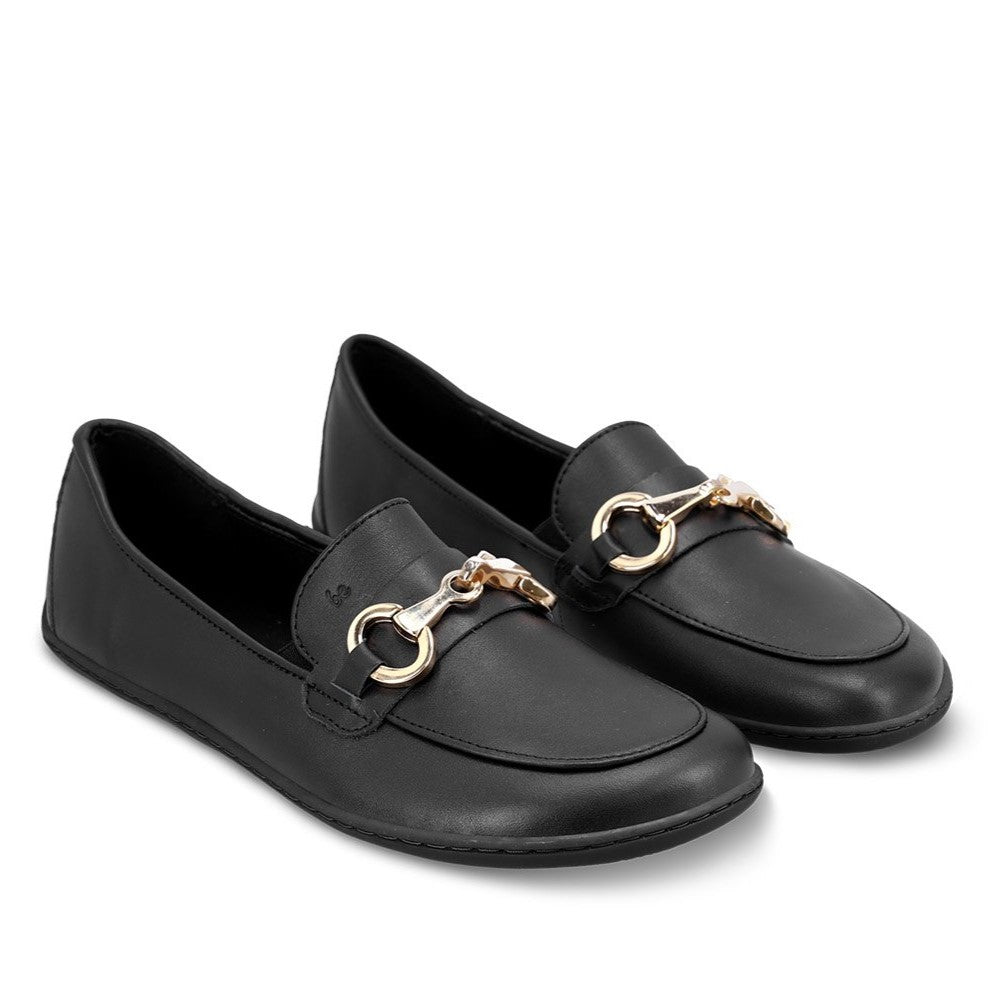 A photo of Black Be Lenka Viva leather loafers. A gold buckle detail graces the vamp. TR soles are stitched on for longevity. Both shoes are shown here diagonally facing slightly right against a white background. #color_black