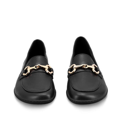 A photo of Black Be Lenka Viva leather loafers. A gold buckle detail graces the vamp. TR soles are stitched on for longevity. Both shoes are shown here from the front against a white background. #color_black