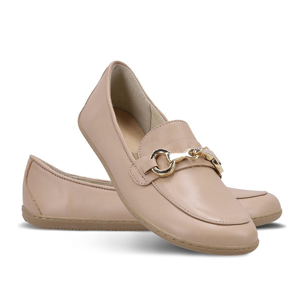 A photo of Latte Brown Be Lenka Viva leather loafers. A gold buckle detail graces the vamp. TR soles are stitched on for longevity. Right shoe is shown here facing right with the right shoe heel propped on top against a white background. #color_latte-brown 