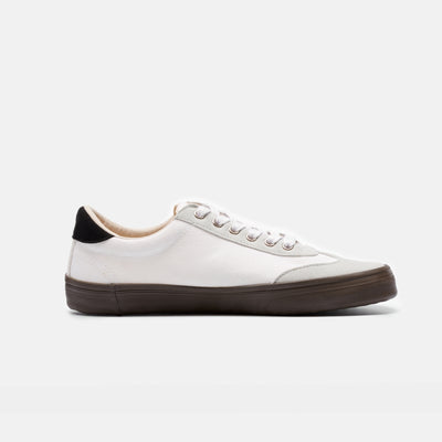 A photo of the Bohempia Felix vegan sneakers made from hemp canvas. The sneakers are white in color with a light grey vegan suede toe cap and a black heel detail, with a dark gum sole and white laces. The left shoe is shown from the right side on a white background. #color_white-dark-gum