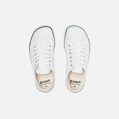 A photo of Bohempia Herlik canvas sneakers made from canvas and rubber soles. The sneakers are light grey with a white toe cap and a black outline around the white rubber soles. Both sneakers are shown from the top down against a white background. #color_white