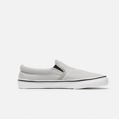 A photo of Bohempia Velik slip on sneakers made from canvas and rubber soles. The sneakers are light grey with white soles with a black stripe around the sole. The left shoe is shown from the right side against a white background. #color_light-grey-white