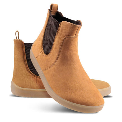 A photo of Be Lenka Entice boots made from nubuck leather and rubber soles. The boots are cinnamon in color, they are a Chelsea boot style with elastic at the sides. Both boots are shown beside each other from the right side, the right boot’s heel is leaning on against the left boot against a white background. #color_cinnamon