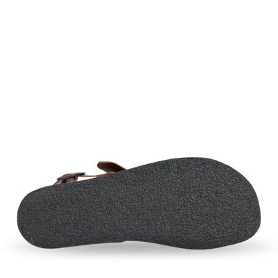 Brown leather Groundies Kos Sandals with black rubber soles. One thick strap spans across the base of the toes while another goes across the arch of the foot with a big, black buckle closure. A thinner slingback strap keeps the sandals secure to the foot also with a buckle closure. Right shoe sole is shown facing right against a white background. #color_cognac