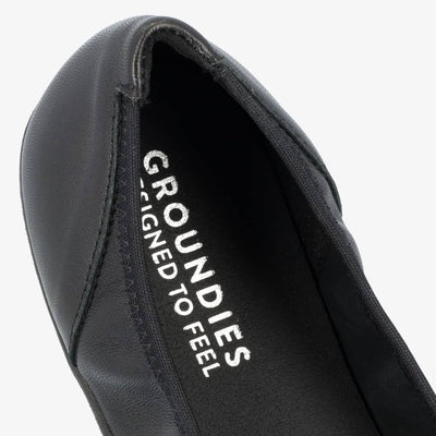 A photo of all black smooth leather Groundies Lily 2 Classic ballet flats. Right shoe insole is shown close up here facing diagonally right against a white background. #color_black