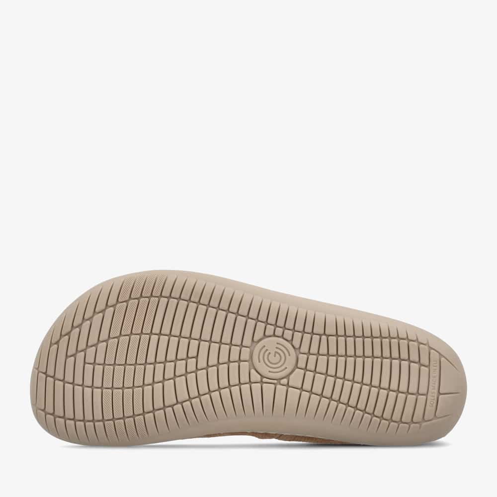 A photo of Groundies Lily Classic flats with a leather upper and tan rubber true sense soles. The flats are a perforated leather in a cognac color with trim around the tops. The interior of the flats is a light beige color. The left shoe is shown from below on a white background, showing the bumpy sole. #color_cognac