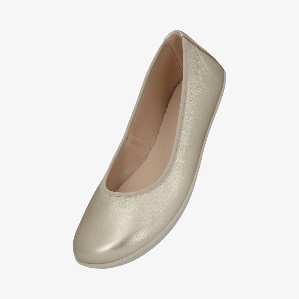 A photo of Groundies Lily Classic flats with a leather upper and tan rubber true sense soles. The flats are a smooth leather in a metallic champagne color with trim around the tops. The interior of the flats is a light beige color. The left flat is shown from the left side floating pointing downward against a white background. #color_metallic-champagne