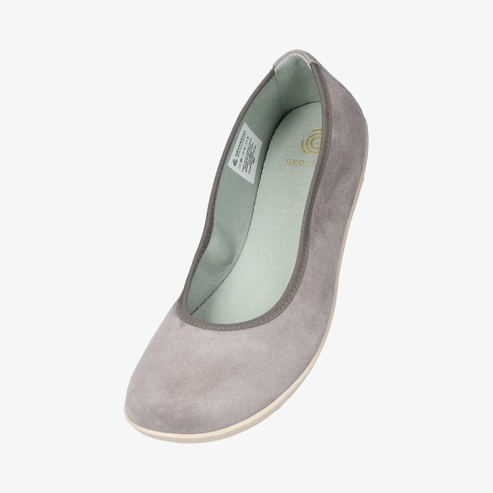 A photo of Groundies Lily Soft flats with a leather upper and cream rubber true sense soles. The flats are a nubuck in a grey color, the trim around the tops of the flats is also grey and is darker in color than the rest of the flats. The left flat is shown from above angled down against a white background. #color_grey