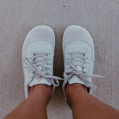 Beige Pink Groundies Nova GO1 leather Sneakers. The sneakers are an off white base leather with suede beige, green, and pink color blocks. Both shoes are shown from above on a dark-skinned woman standing on pavement. #color_beige-pink