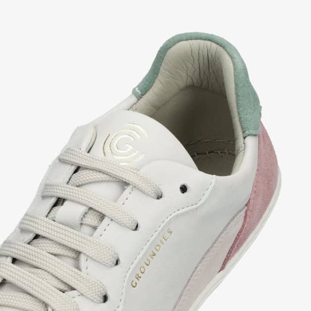 A photo of Groundies Nova GO1 Sneakers made with soft leather and white rubber soles. The sneakers have Beige, Green, and Pink color blocks. The left shoe is shown from above against a white background with a focus on the white laces. #color_beige-green-pink
