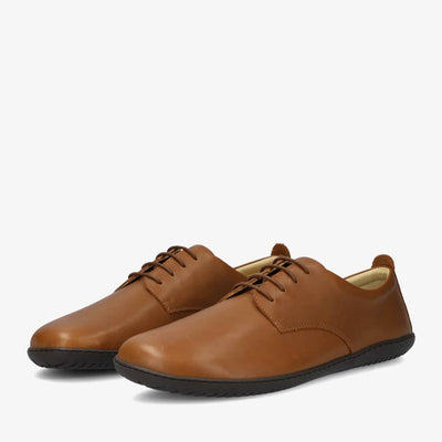 A photo of Groundies Palermo dress shoes made of leather upper and rubber soles. The shoes are a brown color with black soles and dress sole detailing by the laces. Both shoes are shown together from the front left side against a white background. #color_brown