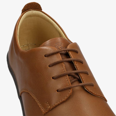 A photo of Groundies Palermo dress shoes made of leather upper and rubber soles. The shoes are a brown color with black soles and dress sole detailing by the laces. The left shoe is shown from above against a white background with a focus on the brown laces. #color_brown