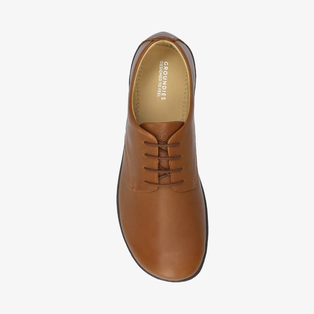 A photo of Groundies Palermo dress shoes made of leather upper and rubber soles. The shoes are a brown color with black soles and dress sole detailing by the laces. The right shoe is shown from above against a white background. #color_brown