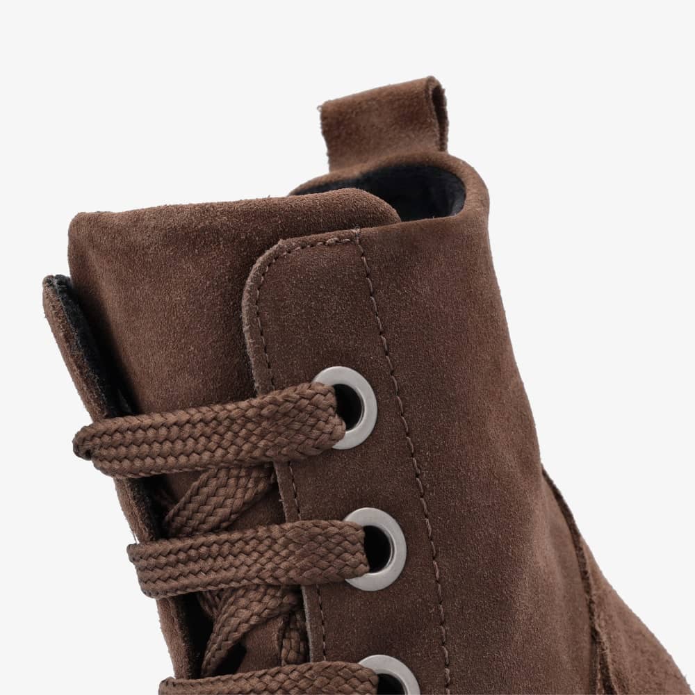 A photo of Groundies Salzburg made from velours leather and rubber soles. The boots are dark brown in color, they are a combat boots style with laces and a zipper on the side. One boot is shown with a close up of the top of the boot against a white background. #color_dark-brown