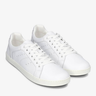 A photo of white Groundies Universe sneakers made of leather with classic sneaker details. Both shoes shown diagonally from the right against a white background in this photo. #color_white