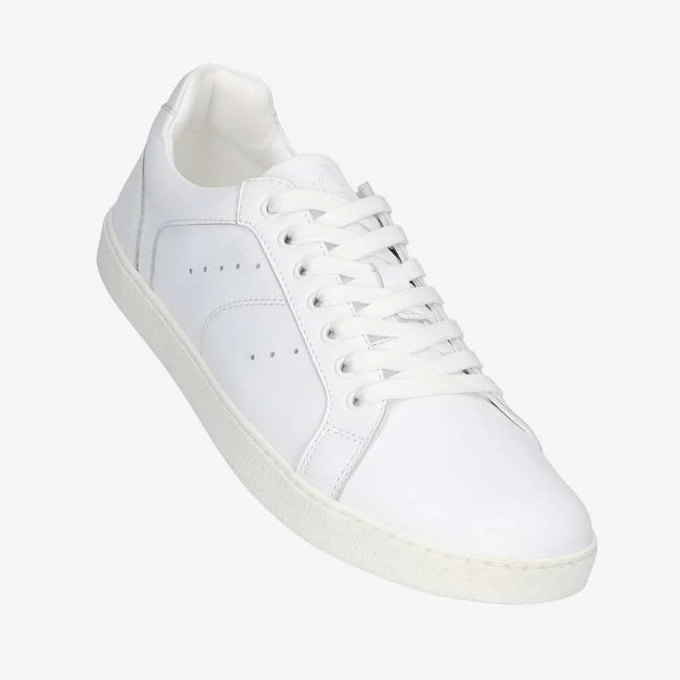 A photo of white Groundies Universe sneakers made of leather with classic sneaker details. Shown diagonally floating from the right side against a white background in this photo. #color_white