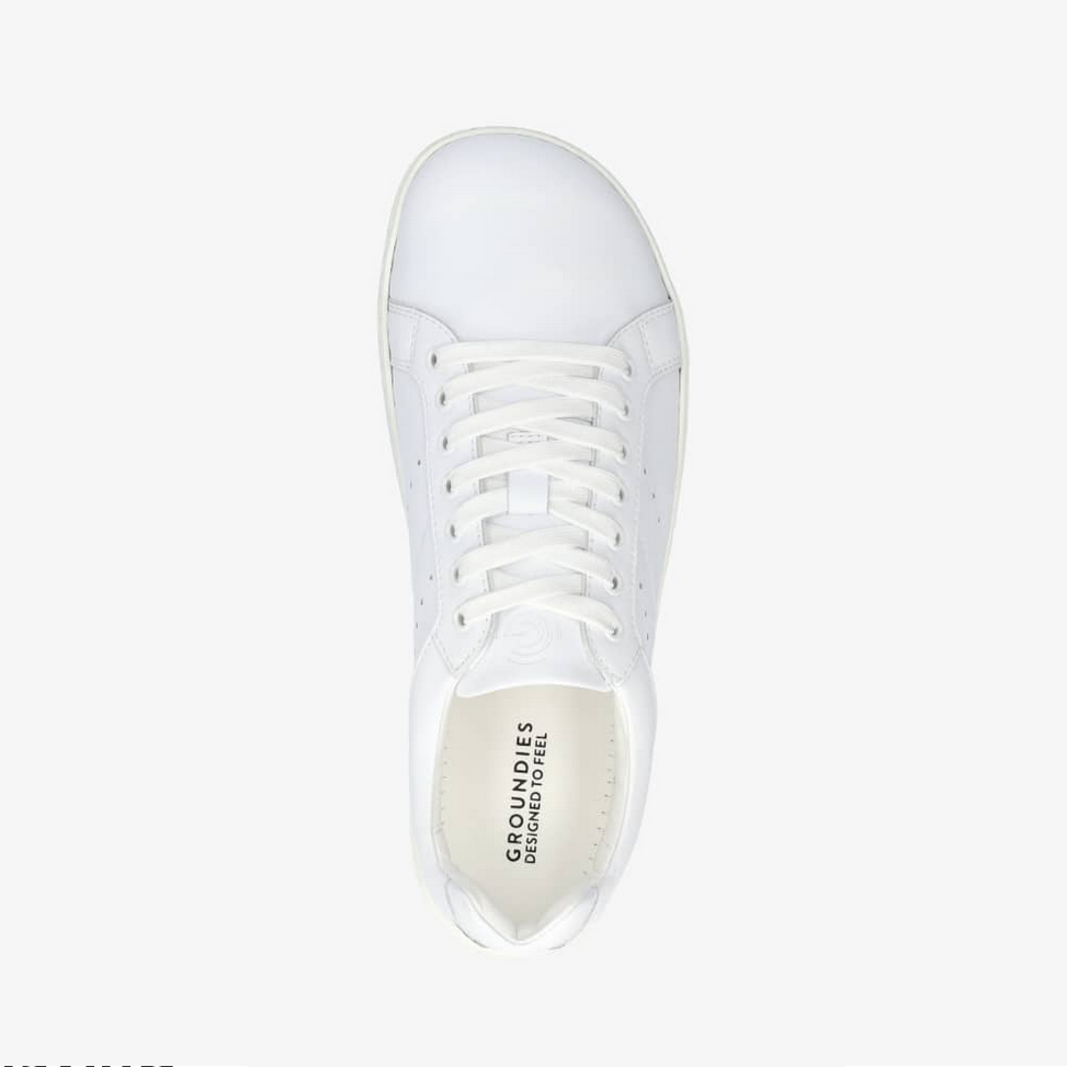 A photo of white Groundies Universe sneakers made of leather with classic sneaker details. Shown from the top down against a white background in this photo. #color_white